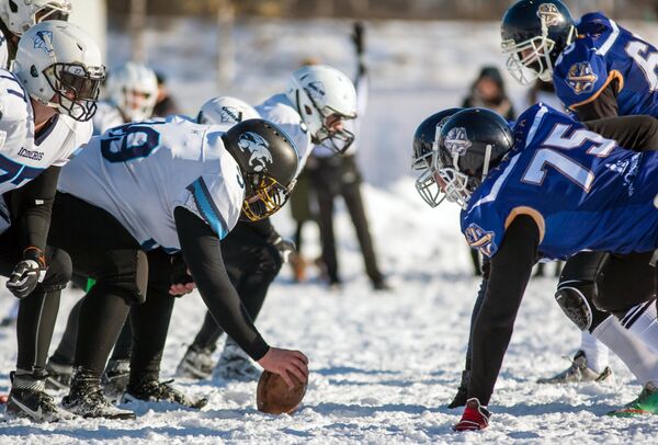Игроки команды Айсберги (слева) и игроки команды Оружейники в матче ежегодного турнира северных городов Snow Bowl 2017 по американскому футболу