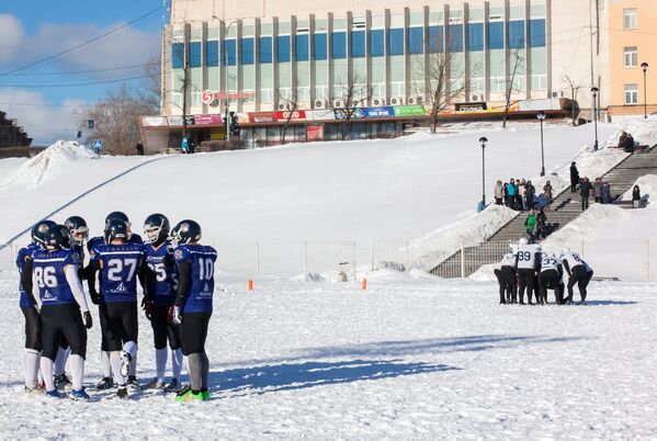 Игроки команды Айсберги (справа) и игроки команды Оружейники перед началом матча ежегодного турнира северных городов Snow Bowl 2017 по американскому футболу