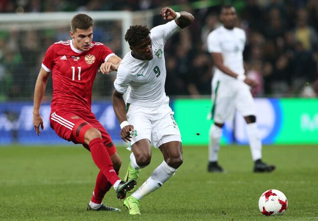 Полузащитник сборной России Роман Зобнин (слева) и нападающий сборной Кот-д'Ивуара Уилфрид Заха