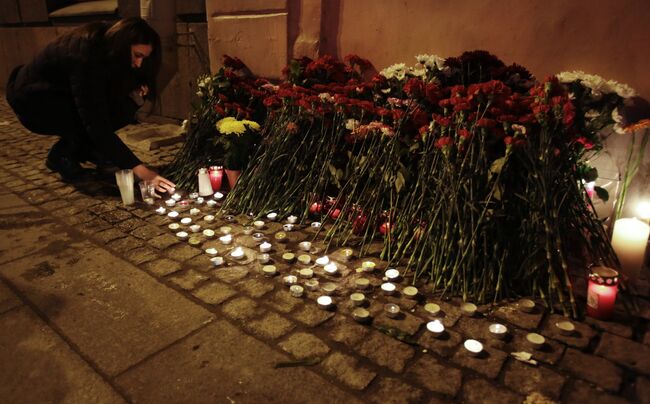Горожане зажигают свечи у входа в вестибюль станции метро Спасская
