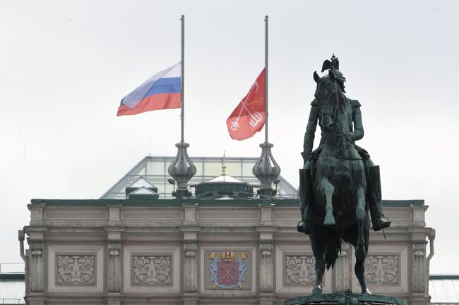 Приспущенные флаги над зданием Мариинского дворца в Санкт-Петербурге в память о погибших в результате взрыва в петербургском метро