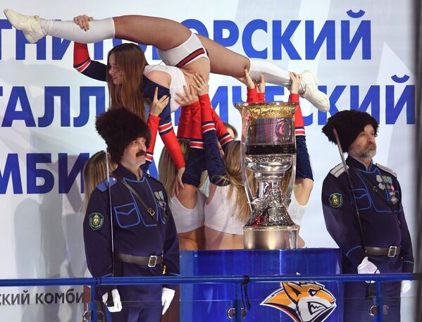 Девушки из группы поддержки и представители казачества у главного трофея Континентальной хоккейной лиги