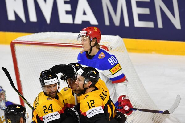 Хоккеисты сборной Германии радуются заброшенной шайбе в матче со сборной России