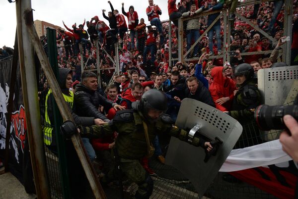 Сотрудники правоохранительных органов сдерживают болельщиков московского Спартака, прорывающихся на поле