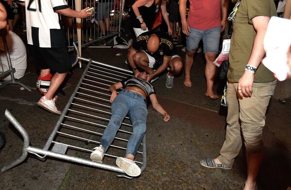 Болельщик Ювентуса оказывает помощь пострадавшей в давке в Турине во время просмотра матча Лиги чемпионов