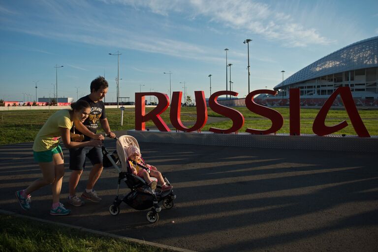 Прохожие у инсталляции Russia 2018 у стадиона Фишт в Олимпийским парке в Сочи Прохожие у инсталляции Russia 2018 у стадиона Фишт в Олимпийским парке в Сочи