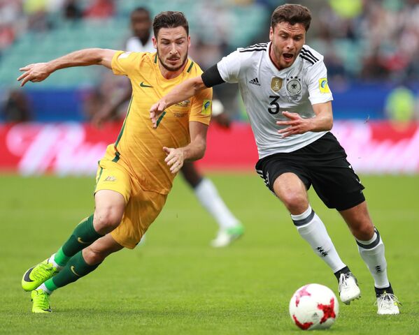 Нападающий сборной Австралии по футболу Мэттью Лек и защитник команды Германии Йонас Хектор (слева направо)