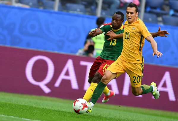 Нападающий сборной Камеруна по футболу (Камерун) и защитник сборной Австралии Трент Сейнсбери (слева направо)