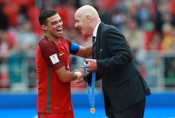Президент ФИФА Джанни Инфантино (справа) вручает медаль защитнику сборной Португалии Пепе