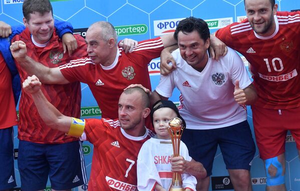 Игрок сборной России по пляжному футболу Антон Шкарин (в центре) на церемонии награждения