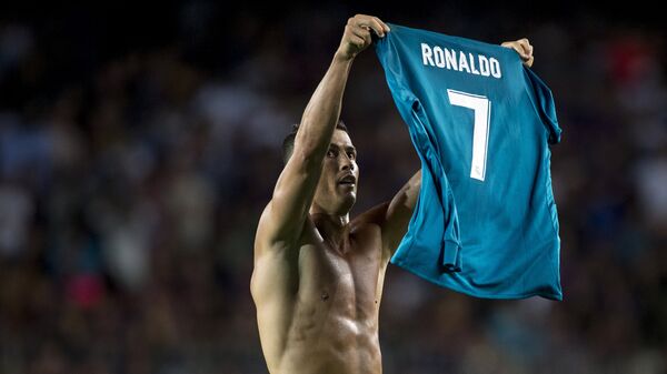 Форвард Реала Криштиану Роналду держит свою футболку после забитого мяча