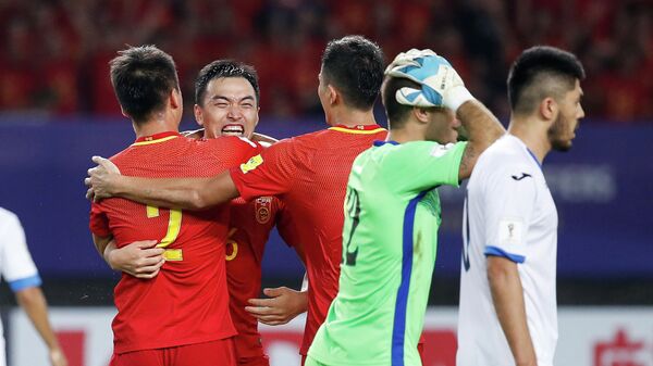 Футболисты сборной Китая радуются забитому мячу в ворота команды Узбекистана