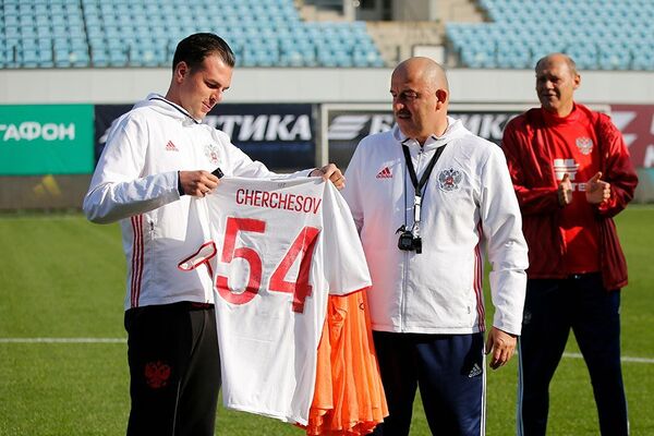 Футболисты сборной России подарили главному тренеру Станиславу Черчесову (в центре) игровую футболку с номером 54 в честь его дня рождения