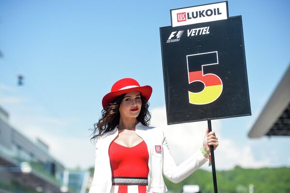 Девушка держит табличку с номером места пилота на трассе перед гонкой на российском этапе Гран-при Формула-1