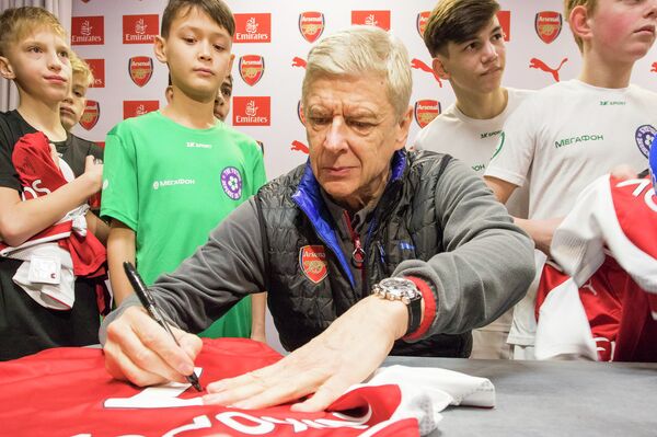 Главный тренер лондонского Арсенала Арсен Венгер раздает автографы