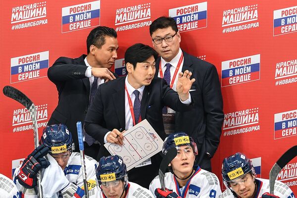 Главный тренер сборной Южной Кореи Джим Пэк по хоккею (справа на втором плане)