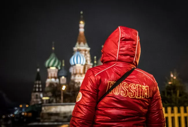 Женщина в экипировке сборной России на фоне Кремля