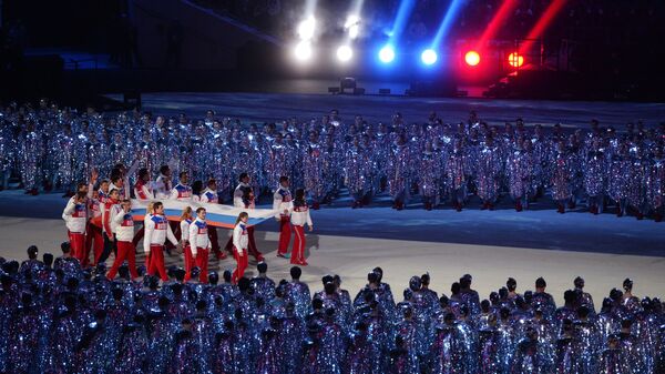 Спортсмены олимпийской сборной России выносят российский флаг