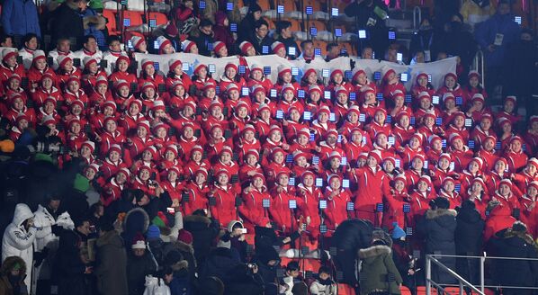 Члены делегации КНДР поют на трибуне перед церемонии открытия XXIII зимних Олимпийских игр
