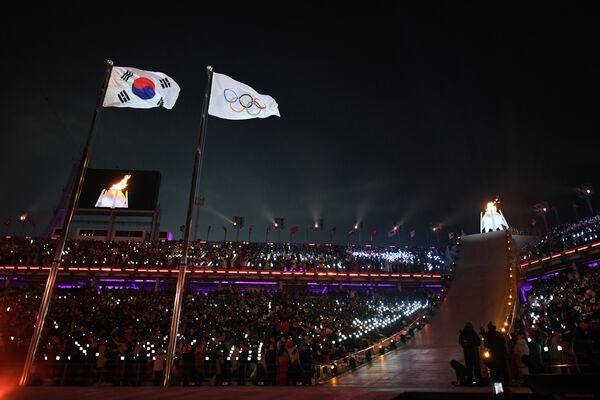 Флаги Южной Кореи - страны-хозяйки Игр, МОК (олимпийские кольца) и олимпийский огонь