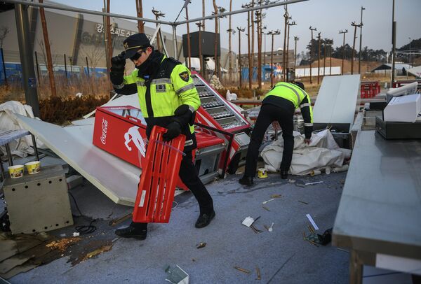 Полицейские во время эвакуации и демонтажа палаток в Олимпийском парке в Канныне из-за сильного ветра