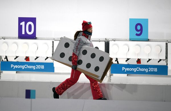 Волонтер на огневом рубеже спринтерской гонки в соревнованиях по биатлону среди женщин на Олимпийских играх в Пхенчхане
