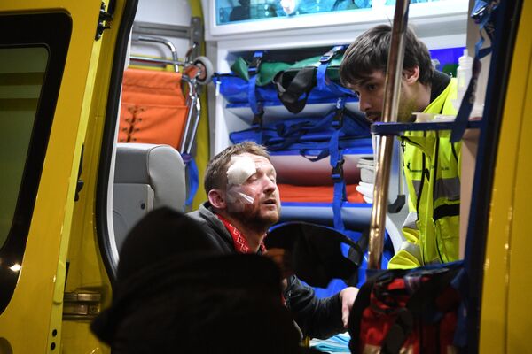 Врачи оказывают медицинскую помощь болельщику, пострадавшему во время столкновения фанатов перед матчем Атлетик - Спартак