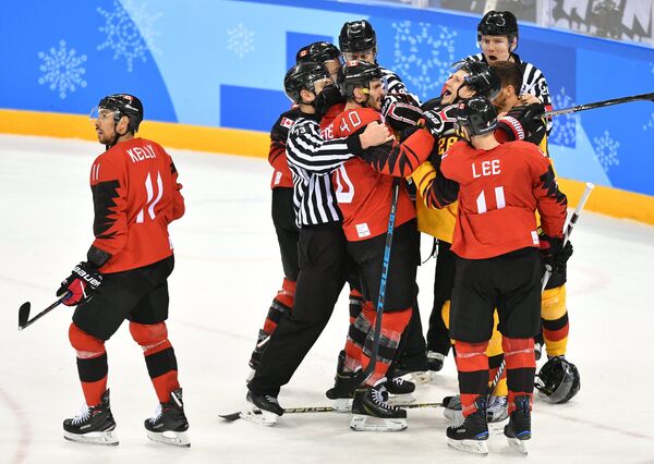 Судьи разнимают игроков в полуфинальном матче Канада - Германия. Слева канадский хоккеист Крис Келли