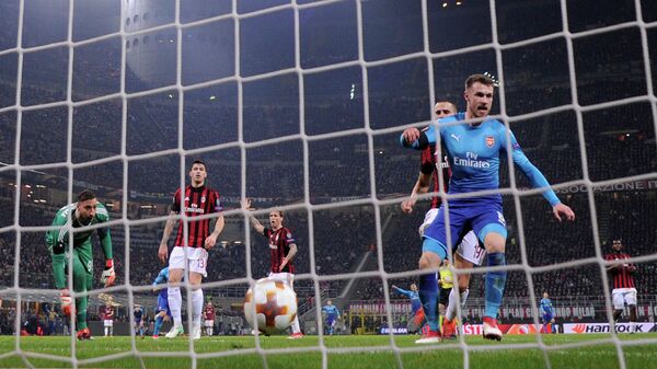 Хавбек Арсенала Арон Рэмзи (справа) радуется забитому мячу в ворота Милана
