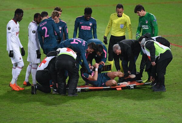 Медики укладывают на носилки защитника ФК Атлетико Филипе Луиса