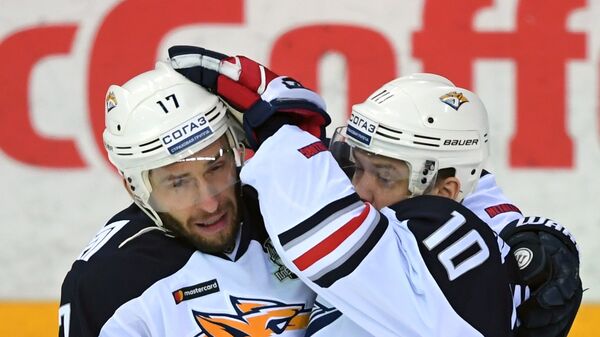 Хоккеисты Металлурга Войтек Вольский (слева) и Сергей Мозякин радуются заброшенной шайбе