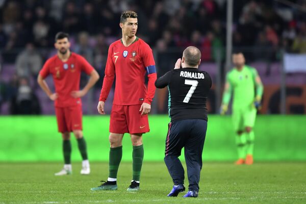 Криштиану Роналду и болельщик, выбежавший на поле во время матча Португалия - Нидерланды