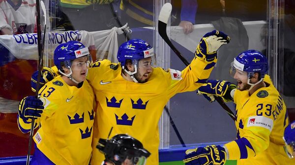 Хоккеисты сборной Швеции Маттиас Янмарк, Мика Зибанеджад и Оливер Экман-Ларссон (слева направо) радуются заброшенной шайбе