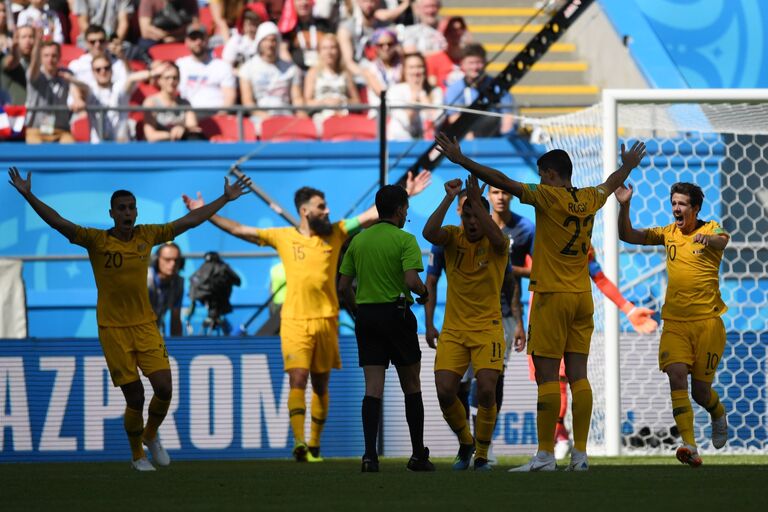 Игроки сборной Австралии указывают судье на игру рукой