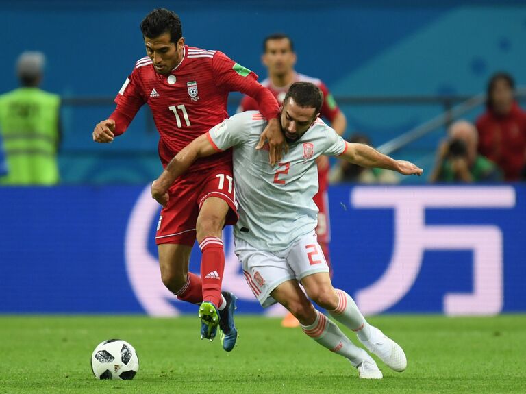 Полузащитник сборной Ирана Вахид Амири и защитник сборной Испании Дани Карвахаль (слева направо) Полузащитник сборной Ирана Вахид Амири и защитник сборной Испании Дани Карвахаль (слева направо)