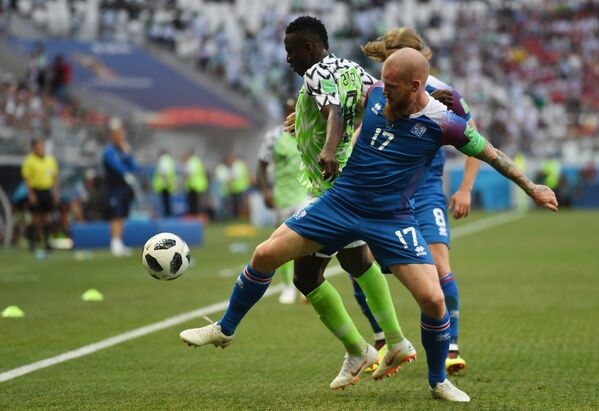 Нигерийский полузащитник Огенекаро Этебо и полузащитник сборной Исландии Арон Гуннарссон (Слева направо)