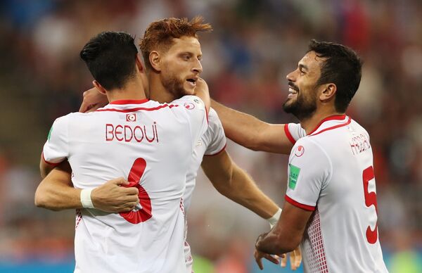 Футболисты сборной Туниса Рами Бедуи, Фахреддин Бен-Юссеф и Уссама Хаддади (слева направо) радуются забитому мячу