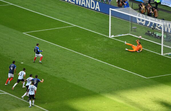 Французский нападающий Антуан Гризманн забивает гол в ворота аргентинского голкипера Франко Армани (слева направо)