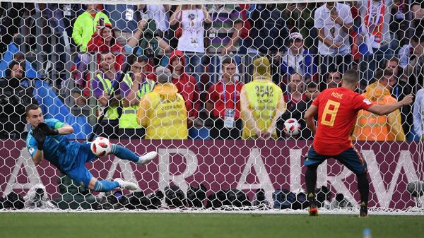 Российский вратарь Игорь Акинфеев отбивает удар с пенальти испанского футболиста Коке (Слева направо)