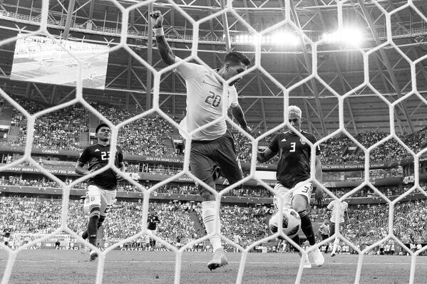 Хавбек сборной Бразилии Роберто Фирмино забивает мяч в ворота Мексики
