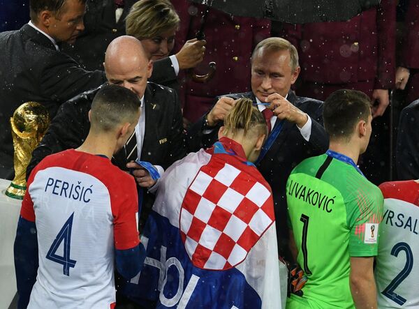 Президент РФ Владимир Путин награждает серебряной медалью защитника сборной Хорватии Домагоя Виду
