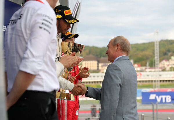 Президент РФ Владимир Путин награждает пилота Мерседеса Льюиса Хэмилтона с победой на Гран-при России