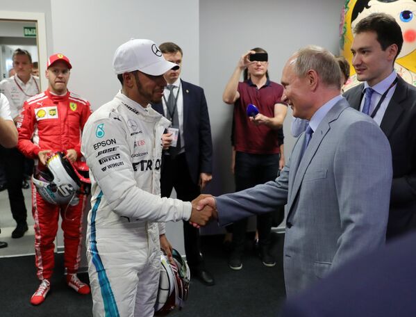 Президент РФ Владимир Путин (справа) и пилот команды Мерседес Льюис Хэмилтон после окончания гонки Гран-при России