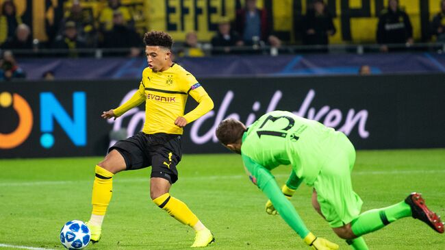 Хавбек дортмундской Боруссии Джейдон Санчо забивает мяч в ворота Атлетико