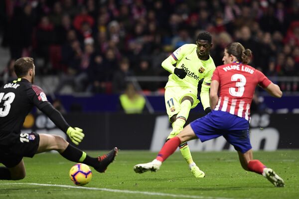 Полузащитник Барселоны Усман Дембеле забивает мяч в ворота Атлетико