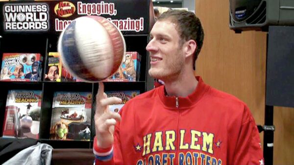 Самый высокий в мире баскетболист вертит мяч одним пальцем во время беседы