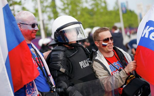 Россйиские болельщики фотографируются с полицейским