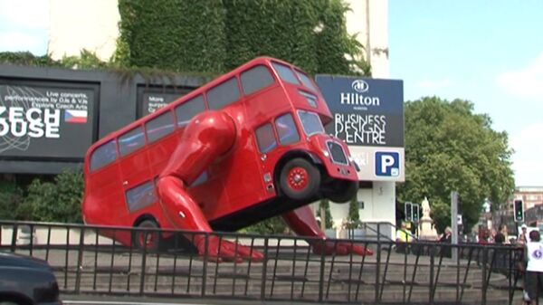 Красный двухэтажный автобус отжимается на лондонской улице