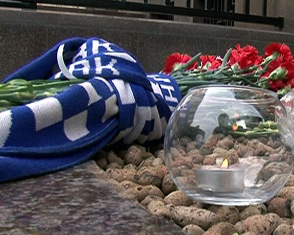 Свечи, цветы и шарфы в память о погибших хоккеистах у посольства Чехии