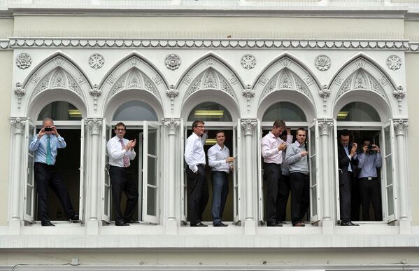 Сотрудники офисов наблюдают за торжественным парадом в честь олимпийцев и паралимпийцев в Лондоне